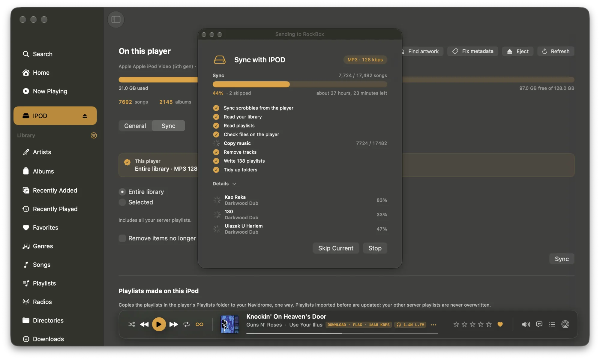 A whole library going onto an iPod Video 5th generation in NaviBeat for macOS. Entire library is selected, and a Sending to RockBox sheet is open over the window: MP3 at 128 kbps, 7,724 of 17,482 songs at 44 percent with two skipped and about 27 hours left, a checklist from Sync scrobbles through Tidy up folders, and three tracks converting under Details.